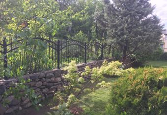 Металната ограда в комбинация от гладко и ковано желязо